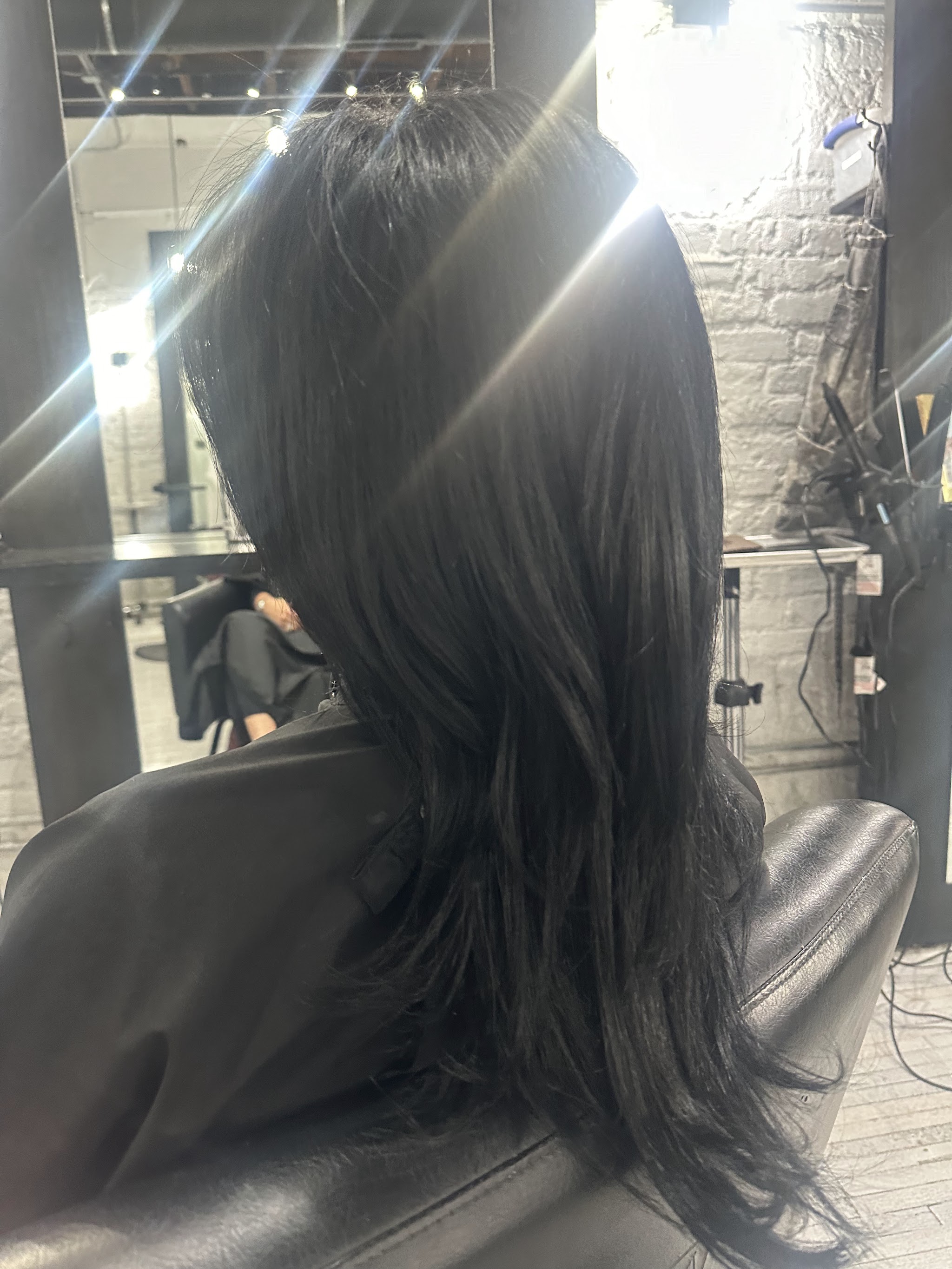 Long dark layered hair in the salon chair